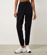 Pantalón jogger deportivo de microfibra, color tostado, con cintura elástica ajustable y puños elásticos en los tobillos. Diseño funcional y liviano, ideal para actividades físicas.