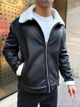 Campera de cuero sintético con interior y cuello forrados en corderito sintético. Presenta cierre frontal metálico, bolsillos laterales y puños con detalle de corderito.
