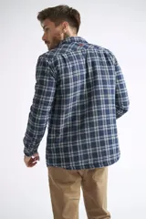 Sobrecamisa de viyela para hombre con estampado de cuadros en rojo y negro. Presenta cierre frontal con botones, bolsillos en el pecho con solapa y botón, y un interior capitoneado para mayor abrigo. Cuenta con un logo en grifa de cuero.