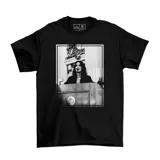 Remera negra de manga corta con estampa fotográfica en blanco y negro en el frente que muestra a una mujer en un estrado.