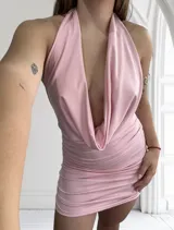 Minivestido rosado con escote halter y espalda descubierta. Diseño drapeado y ajustado al cuerpo.