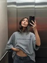 Remera oversize gris con efecto acid wash y estampa frontal con la leyenda "WORLDWIDE TOUR" en tipografía gótica.