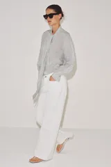 Camisa de viscosa con estampado de lunares pequeños, escote en pico con lazada frontal, manga larga y puños anchos.