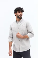 Camisa de gabardina color gris claro con efecto stone wash, doble bolsillo frontal con solapa y botones, y fit regular.