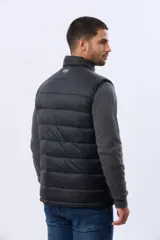 Chaleco reversible acolchado con diseño capitoneado. Un lado presenta un acabado en color beige con cierre frontal y bolsillo vertical en el pecho, mientras que el otro lado es de color azul marino. Cuenta con cuello alto y relleno térmico para mayor abrigo.