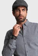 Camisa de manga larga con cuello abotonado y puños ajustables, confeccionada en tela Oxford de algodón a cuadros en blanco y negro.