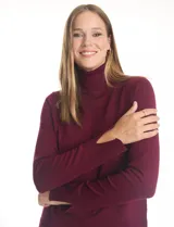 Polera de tejido fino, color rosado, con cuello alto, manga larga y detalle de tajo en los puños.