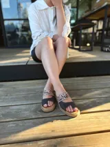 Sandalias bajas de cuero con dos tiras, una de cuero liso color gris y otra con estampado animal print.