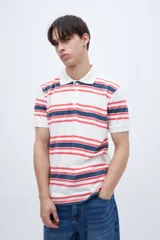 Chomba teñida en prenda con estampado a rayas, confeccionada en algodón lavado. Presenta media cartera de botones y bordado en el pecho.