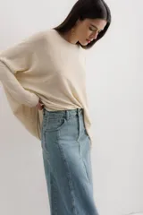 Sweater beige de manga larga, cuello redondo y corte holgado.