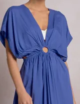 Vestido midi túnica color azul de la marca Elan, de corte holgado con escote en V profundo y mangas mariposa. Cuenta con una argolla central forrada que une el fruncido del busto y genera sutiles aberturas cut-out en la cintura. Presenta cintura elastizada y falda fluida con tajo lateral.