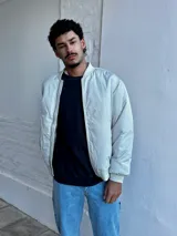 Campera bomber color crudo de nylon con cierre frontal y bolsillos laterales.