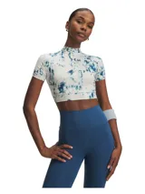 Remera deportiva Under Armour de corte crop y cuello alto, con mangas cortas raglán. Presenta un estampado tipo tie-dye en tonos azul y blanco, con el logo de la marca en el centro del pecho.