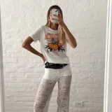 Remera blanca de algodón con estampado de naranjas y texto en color naranja.