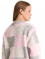 Buzo de punto con diseño de cuadros en tonos rosa y gris, de cuello redondo, manga larga y corte holgado.