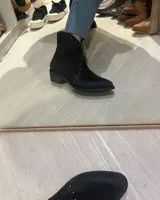 Botas texanas cortas de cuero vacuno color marrón con detalles de cuero marrón oscuro y tachas plateadas.