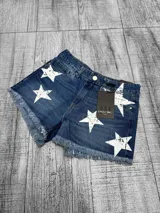 Short de jean azul de tiro medio, con estampado de estrellas blancas desgastadas y bordes desmechados en las piernas.