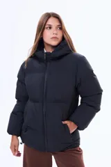 Campera puffer negra con capucha, cierre frontal completo y bolsillos laterales. Diseño acolchado de corte estándar con puños elásticos.