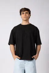 Remera de algodón negro con efecto deslavado, corte holgado, mangas cortas y cuello redondo.
