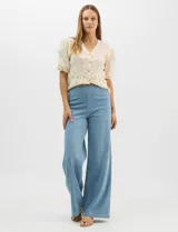 Jegging de tiro alto con silueta estilo palazzo y pierna amplia, confeccionado en tejido denim. Presenta una pretina ancha elástica sin cierre frontal, diseño frontal liso sin bolsillos y dos bolsillos traseros tipo parche.