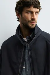 Cazadora de corte cropped confeccionada en tejido de algodón con ligero acolchado interior. Presenta cuello subido, cierre frontal con cremallera, mangas largas con puños elásticos y bolsillos laterales de vivo.