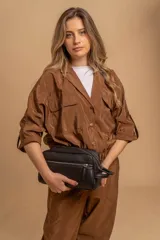 Neceser unisex de cuero sintético negro, con forma rectangular y asas laterales. Presenta un compartimento principal con doble cierre superior y un bolsillo frontal con cierre vertical.