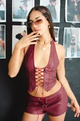 Short de cuero sintético color borgoña, de tiro alto y corte ajustado, con cordones cruzados en el frente.