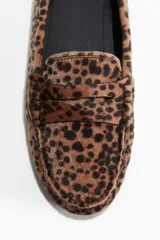 Mocasines tipo penny con pelo sintético estampado de leopardo. Presentan costura tradicional en el empeine y forro interior de sarga de algodón.