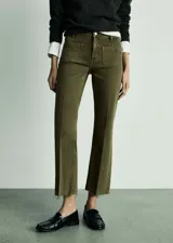 Pantalón tipo jeans de tiro medio en color verde oliva, con diseño acampanado y bajo deshilachado. Presenta dos bolsillos de parche en la parte delantera, cierre de cremallera y botón, y trabillas para cinturón.