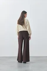 Pantalón de pana de corte wide leg, color marrón oscuro, con calce relajado y detalle de bordado en el borde de los bolsillos delanteros.