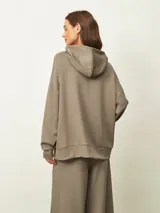 Buzo azul oscuro con capucha, corte oversize, manga larga y bolsillo canguro frontal.