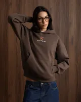 Hoodie de algodón color marrón con capucha y estampado gráfico en la espalda que incluye texto y logo de la marca.