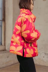Campera puffer acolchada con estampado floral en tonos fucsia y naranja, cuello alto y cierre frontal.