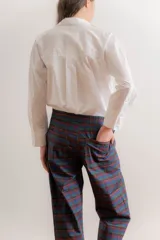 Pantalón de corte relajado con estampado de cuadros escoceses en tonos azul, verde y bordó. Presenta cintura elástica en la parte posterior, cordón de ajuste frontal y terminación en el ruedo con detalle de frunce ajustable.