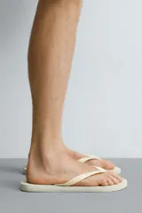 Sandalias de goma blanca Havaianas x Zara, con suela plana con relieve y tiras en el empeine con textura.