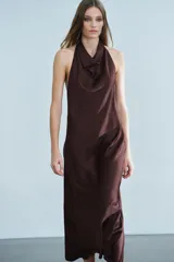 Vestido midi de tejido satinado en color marrón oscuro, con cuello halter de escote fluido, hombros descubiertos y cierre posterior con botones.