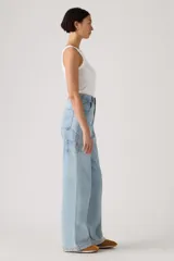 Pantalón de jean estilo carpenter con corte baggy y pierna ancha. Presenta tiro alto, bolsillos laterales y traseros, y costuras reforzadas características del diseño utilitario.