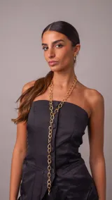 Collar corbatero de acero dorado con eslabones circulares texturizados entrelazados en diseño largo.