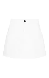 Short pollera de algodón blanco, con cintura alta, corte recto, bolsillos laterales y cierre frontal con botón y cremallera.
