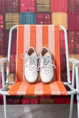 Championes de cuero blancos con suela de goma color caramelo y cordones moteados en blanco y negro.