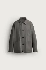 Sobrecamisa gris de corte regular fit con textura, cuello solapa, cierre frontal de botones, bolsillos de parche en el pecho y los laterales, y mangas largas con puños abotonados.