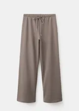 Pantalón de corte ancho, estilo relaxed, color gris topo, con cintura elástica ajustable mediante cordón.