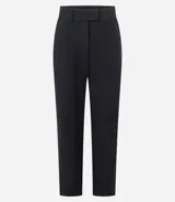 Pantalón de vestir negro, estilo carrot (holgado en cadera y ajustado en tobillo), de cintura alta con trabillas y cierre tradicional. Presenta recortes verticales con costura aparente en el frente.
