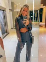 Mono largo negro con cuello alto, mangas largas de tul y abertura en el abdomen.