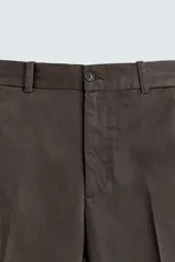 Pantalón chino de corte regular fit, confeccionado en tejido de algodón con estructura diagonal. Presenta bolsillos frontales, bolsillos traseros de vivo con botón y cierre frontal con cremallera y botón.