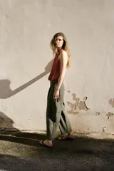 Pantalón cargo de tiro bajo color verde militar, con pinzas delanteras, pernera recta, bolsillos frontales y bolsillos laterales de plastrón. Cuenta con cierre frontal de cremallera y botones.