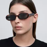 Lentes de sol ovalados con montura carey y lentes verdes oscuros polarizados.