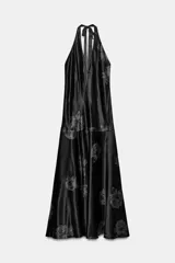 Vestido largo de tejido satinado con cuello halter ajustable mediante lazada en la espalda. Presenta un diseño fluido con estampado floral a contraste.