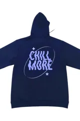 Canguro negro con capucha y bolsillo tipo canguro, confeccionado en mezcla de poliéster y algodón. Presenta un diseño gráfico en la espalda con el texto "CHILL MORE" en tipografía psicodélica, rodeado por una órbita elíptica y dos estrellas.