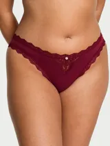 Panty tipo bikini color bordó, de talle medio, con detalles de encaje en la cintura y los bordes, y un pequeño aplique decorativo en el centro.